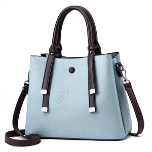 Light blue and brown textured leather handbag with fringe details and crossbody strap