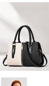 Close-up of structured bicolor handbag with quilted texture and gold zipper detail