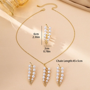 Summer gold leaf pearl jewelry set including necklace and earrings on silk background