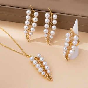 Detailed view of leaf design jewelry set with pearls on gold metal base