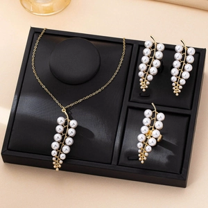 Elegant gold leaf and pearl jewelry set featuring a necklace, earrings, and ring on a display