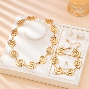 Parure de bijoux dorés avec collier et bracelet à maillons en spirale sur support
