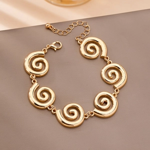 Detailed view of golden swirl link bracelet with lobster clasp and adjustable chain