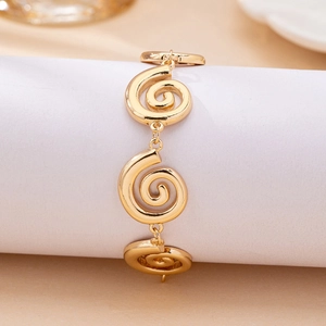 Elegant golden swirl link bracelet with vintage spiral texture on a white display stand