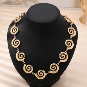 Elegant gold spiral swirl disc necklace displayed on a black neck mannequin for women
