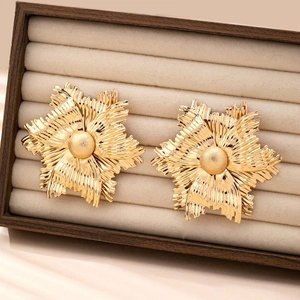 Chic oversized gold flower earrings featuring a textured 3D floral design in a jewelry box