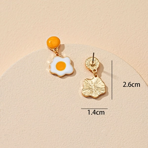 Vue détaillée des boucles d'oreilles œuf au plat avec dimensions 2.6cm par 1.4cm sur socle