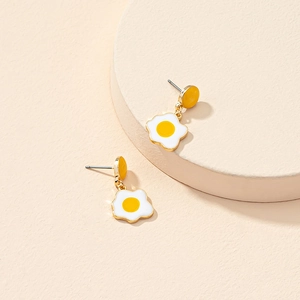 Boucles d'oreilles minimalistes en émail en forme d'œuf sur plat sur un présentoir beige