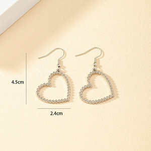 Detail view of hollow heart earrings with dimensions 4.5cm by 2.4cm in silver finish