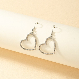 Elegant silver hollow heart earrings made of micro-beads on white display stand