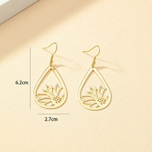 Détail de boucles d'oreilles goutte dorées avec motif tournesol ajouré, hauteur 6,2 cm
