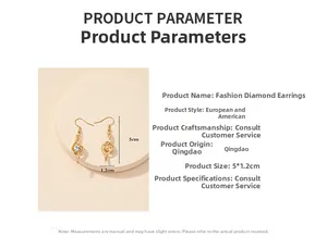 Detail view of gold dangle earrings with sparkling rhinestones measuring 5 by 1.2 cm