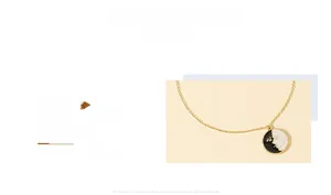 Detail of vintage gold chain necklace featuring black and white enamel face coin pendant