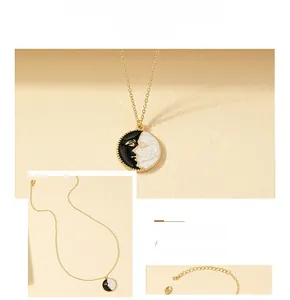 Macro detail of gold vintage coin pendant with black and white enamel sun moon face