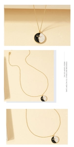Detailed macro view of vintage gold coin necklace with black and white enamel face design