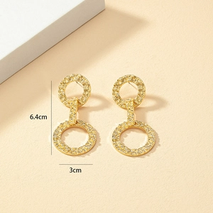 Détail de grandes boucles d'oreilles créoles dorées texturées, 6,4 cm sur 3 cm