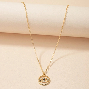Collier avec pendentif Mauvais Œil doré et cristaux sur support d'exposition épuré