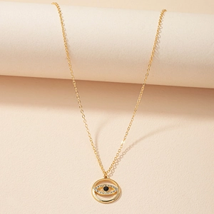 Détail du pendentif œil avec cristaux sur un collier délicat à chaîne dorée en O