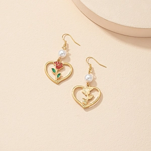 Dettaglio di orecchini a cuore con rosa, perle bianche e ganci placcati in oro