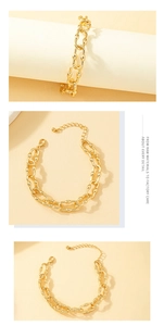 Detail view of gold alloy chain bracelet with engraved oval links and lobster clasp