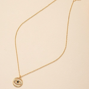 Détail du collier pendentif œil maléfique doré avec pavé de cristaux et pierre noire