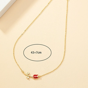 Detail of gold tulip necklace with 43+7cm chain length measurement on textured backdrop