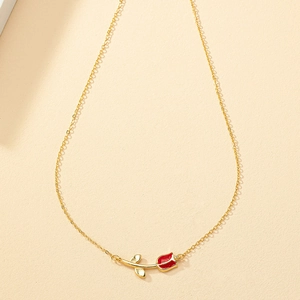 Elegant gold chain necklace featuring a red enamel tulip pendant on a beige background