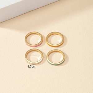 Set of four gold spring rings with colorful enamel bands and a 1.7cm inner diameter
