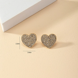 Close-up of gold heart stud earrings with sparkling pave rhinestones and dimensions