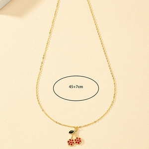 Détail du collier chaîne dorée 45+7cm avec pendentif cerise en émail rouge
