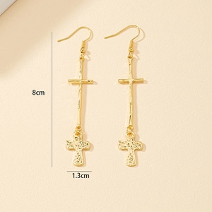 Detail shot showing gold cross drop earrings with hammered texture and dimensions