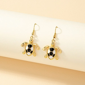 Golden sea turtle drop earrings with black and white hexagonal enamel shell pattern