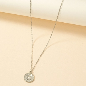 Silver vintage cross coin pendant necklace with embossed details on textured background