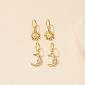 Gold celestial sun and moon face earrings in a minimalist bohemian vintage style