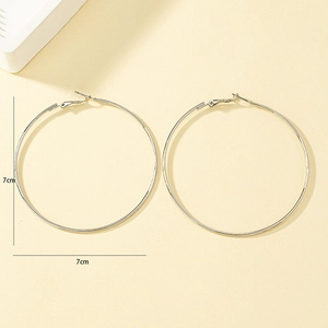 Detail view of 7cm oversized silver polished hoop earrings with minimalist circular design