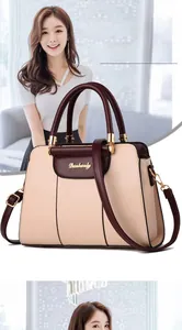 Detail of Danbaoly tote bag showing beige and wine red contrast leather with gold logo