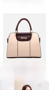 Close-up of beige and burgundy shoulder bag with gold hardware and large capacity