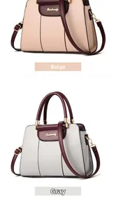 Detail view of large PU leather shoulder bags in beige and gray with gold metal logo