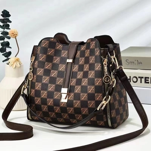 Detail of checkered shoulder bag with letter prints and decorative metal chain