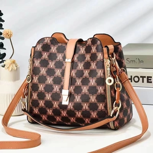 Retro bucket bag with contrast monogram print and gold hardware in a lifestyle setting