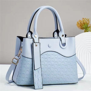 Elegant light blue textured tote bag with woven leather pattern and adjustable shoulder strap