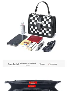 Detail view of the houndstooth crossbody bag interior with magnetic closure and pocket