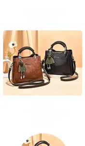 Detailed view of textured oil wax leather handbags with plush charms and adjustable straps