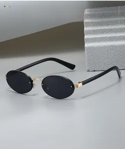 Detailed macro view of vintage oval sunglasses with golden metal bridge and dark lenses