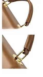 Detail of ergonomic brown leather handle with reinforced gold metal hardware and stitching