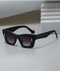 Detail of square black sunglasses featuring gradient purple lenses and silver rivets