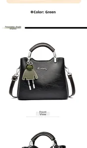 Detail view of green oil-wax leather handbag with Danbaoly logo and cute charm