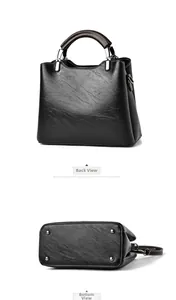 Detail view of the black oil wax leather handbag showing the back and bottom protective studs