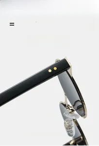 Detail view of silver oval sunglasses featuring gold hinge accents and texture