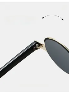 Detail of sturdy gold metal hinge connecting black temple and dark grey lens